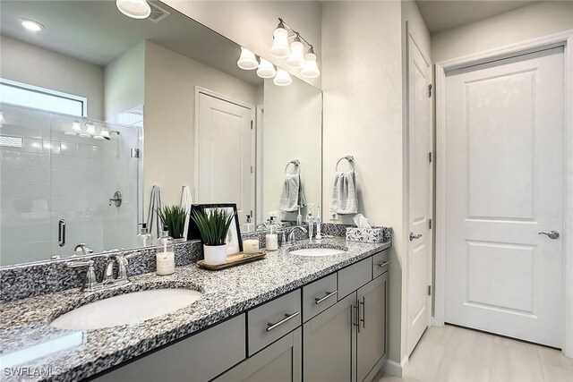 bathroom featuring an enclosed shower and dual bowl vanity