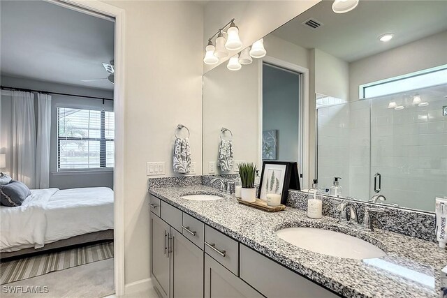 bathroom with a shower with shower door, double sink vanity, a wealth of natural light, and ceiling fan