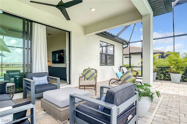 view of patio featuring an outdoor living space, ceiling fan, and glass enclosure