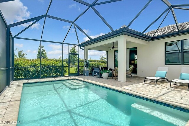 view of swimming pool with a lanai, a patio, and ceiling fan