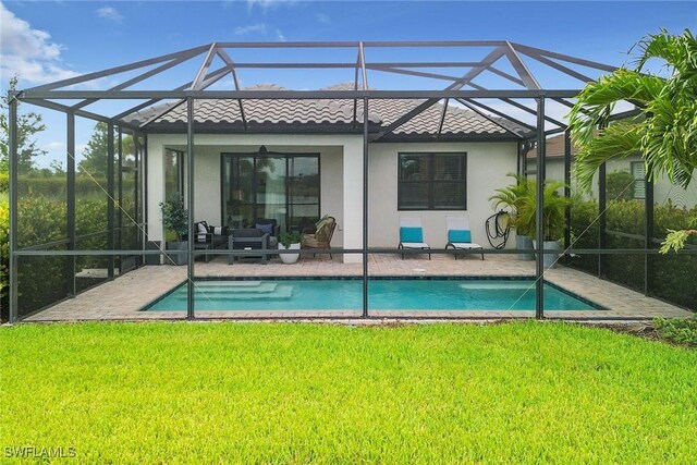 rear view of house featuring a patio area, a yard, and glass enclosure