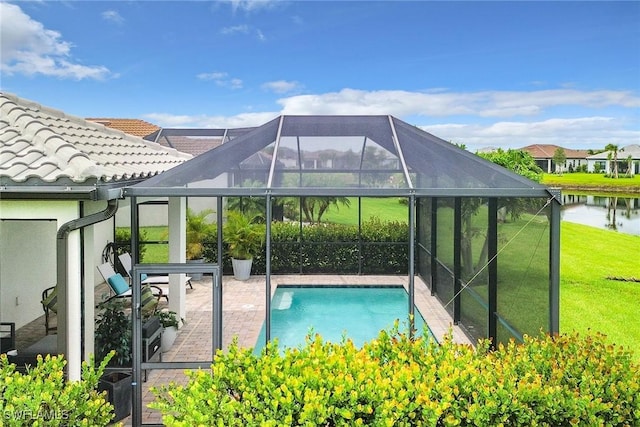 view of swimming pool featuring a yard, a water view, a patio, and a lanai