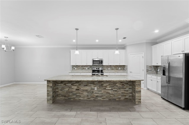 kitchen with white cabinets, light stone counters, stainless steel appliances, and an island with sink