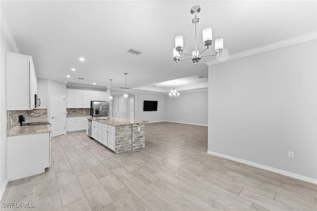 kitchen with pendant lighting, white cabinets, a chandelier, and a kitchen island with sink