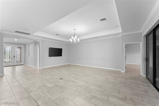 unfurnished room featuring a tray ceiling, french doors, arched walkways, a notable chandelier, and visible vents