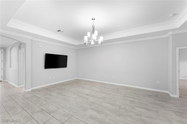 empty room featuring baseboards, visible vents, arched walkways, a tray ceiling, and a notable chandelier