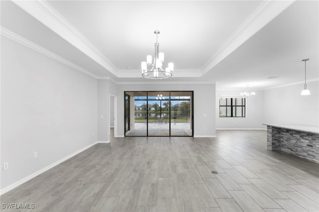 unfurnished living room with a raised ceiling, light wood-style flooring, ornamental molding, a chandelier, and baseboards