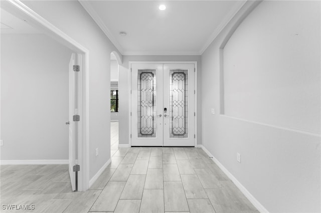 entrance foyer with crown molding and french doors