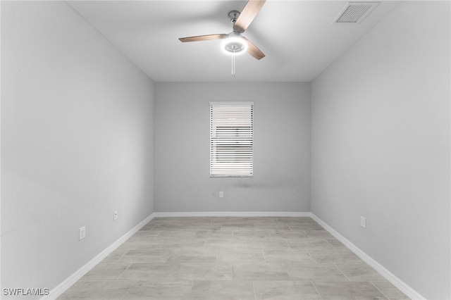 spare room featuring visible vents, ceiling fan, and baseboards