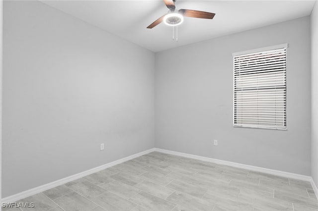 unfurnished room featuring a ceiling fan and baseboards