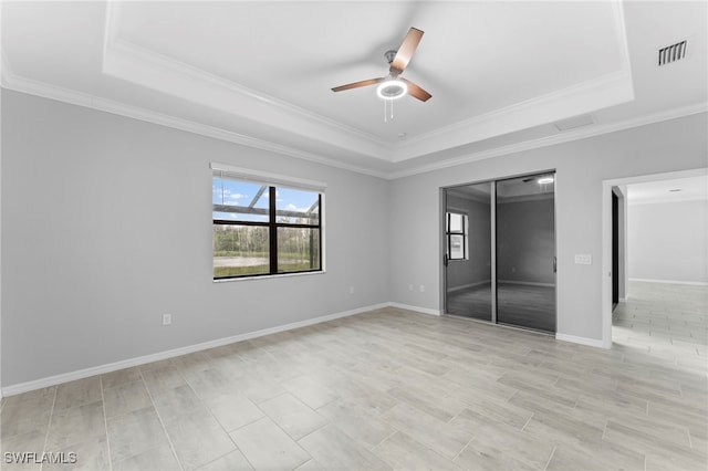 unfurnished bedroom with a closet, a raised ceiling, visible vents, and baseboards