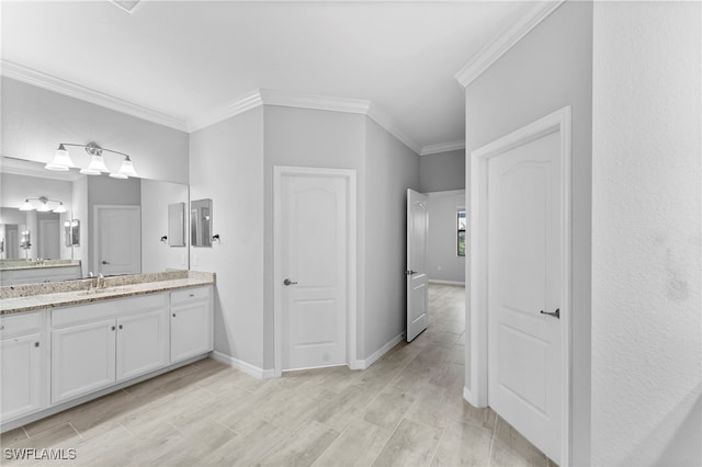 full bath featuring ornamental molding, wood finish floors, vanity, and baseboards