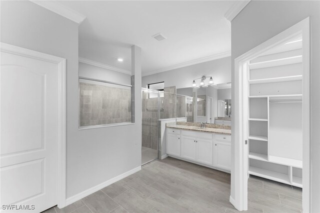 bathroom featuring ornamental molding, vanity, and a shower with door