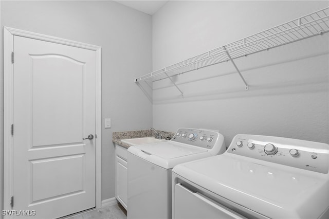 laundry area with washer and dryer, cabinets, and sink