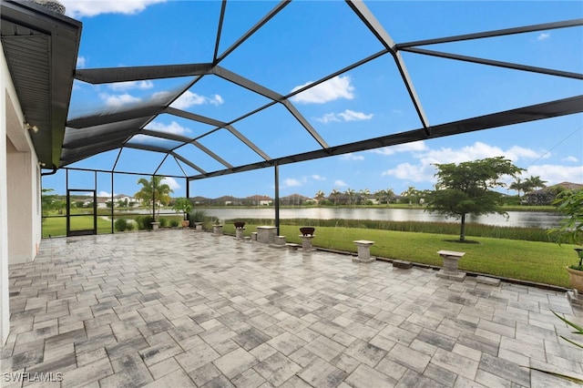 view of patio / terrace featuring glass enclosure and a water view