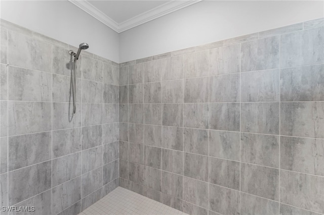 bathroom featuring tiled shower and ornamental molding