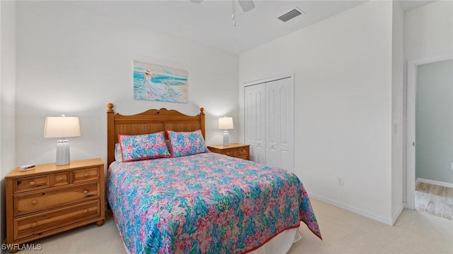 bedroom with ceiling fan, a closet, and light colored carpet