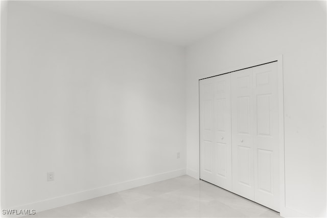 unfurnished bedroom featuring light tile patterned floors and a closet