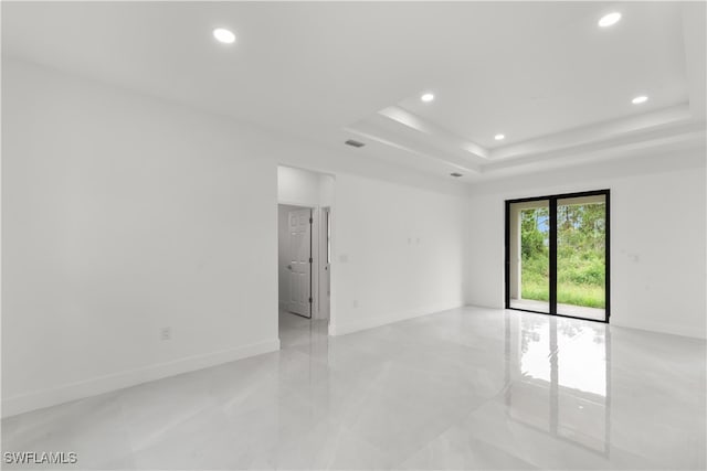 unfurnished room featuring a raised ceiling