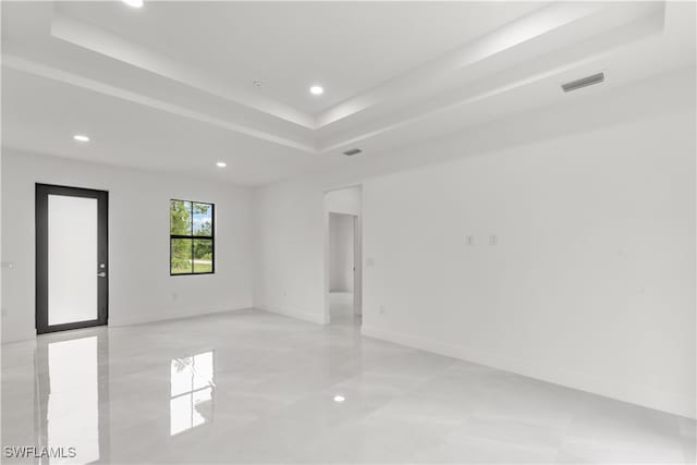 unfurnished room with a raised ceiling