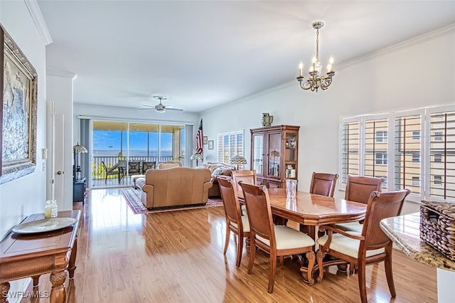 dining area with ornamental molding, ceiling fan with notable chandelier, and light hardwood / wood-style floors