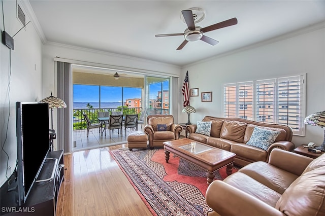 living room featuring hardwood / wood-style flooring, ornamental molding, and ceiling fan