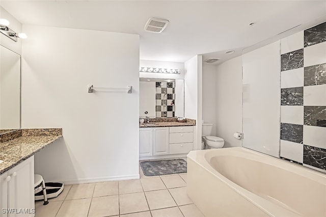 bathroom with vanity, tile patterned flooring, a tub to relax in, and toilet