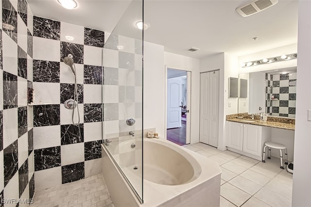 bathroom with vanity, tile patterned floors, combined bath / shower with glass door, and tile walls