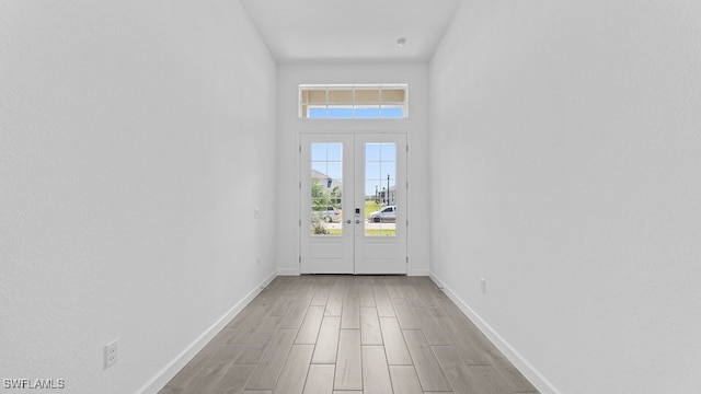 entryway with light hardwood / wood-style flooring, french doors, and a wealth of natural light