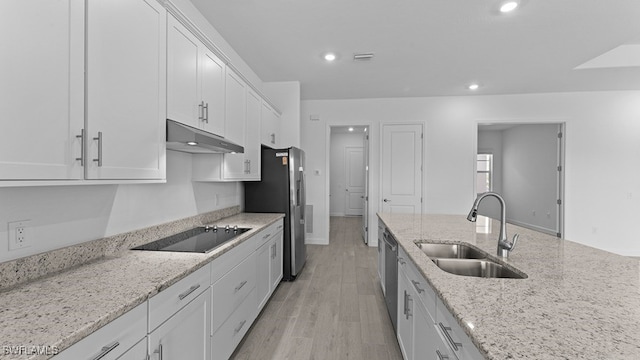 kitchen featuring stainless steel appliances, white cabinets, sink, light hardwood / wood-style floors, and light stone counters