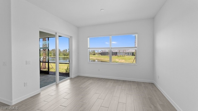 empty room with a water view and light hardwood / wood-style floors