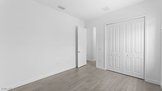 unfurnished bedroom with a closet and light hardwood / wood-style floors