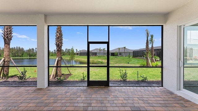 unfurnished sunroom featuring a water view