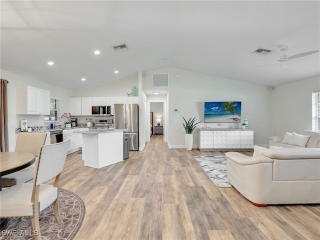 living room featuring vaulted ceiling, light hardwood / wood-style flooring, and ceiling fan