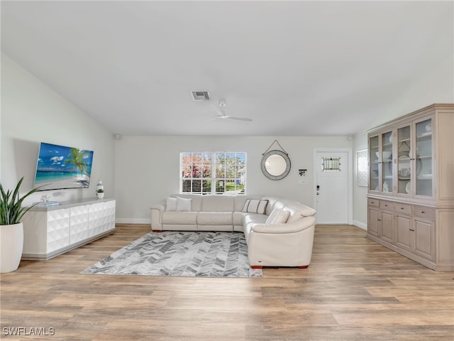 living room featuring lofted ceiling, light wood-type flooring, and ceiling fan