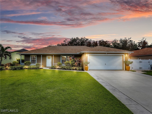 ranch-style house featuring a yard, a garage, and a porch