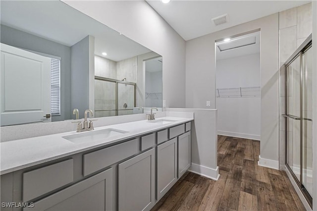 bathroom featuring vanity, a shower with door, and wood-type flooring