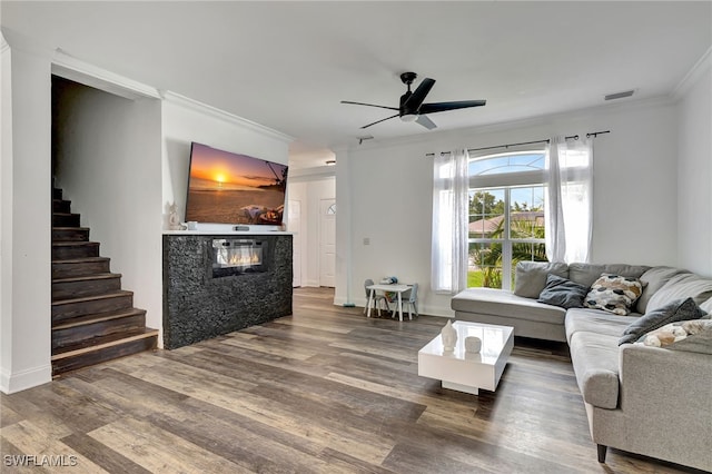 living room featuring ceiling fan, wood-type flooring, and ornamental molding