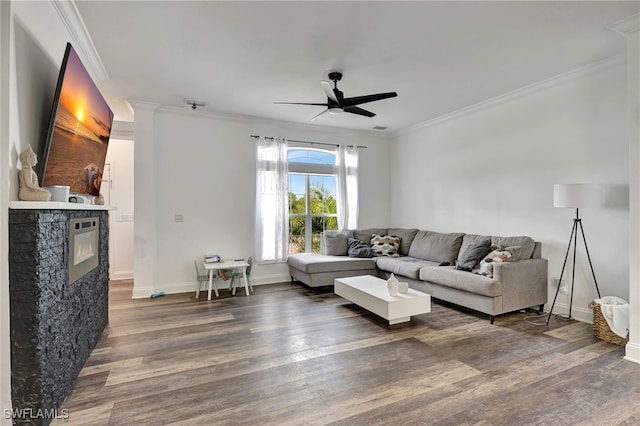 living room featuring ceiling fan, crown molding, a fireplace, and hardwood / wood-style flooring