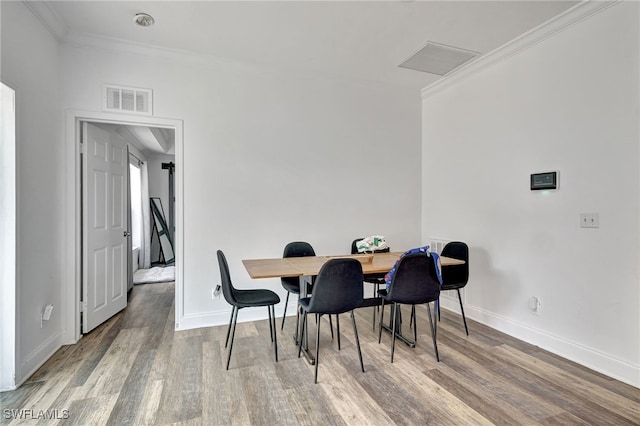 dining area featuring crown molding and hardwood / wood-style floors