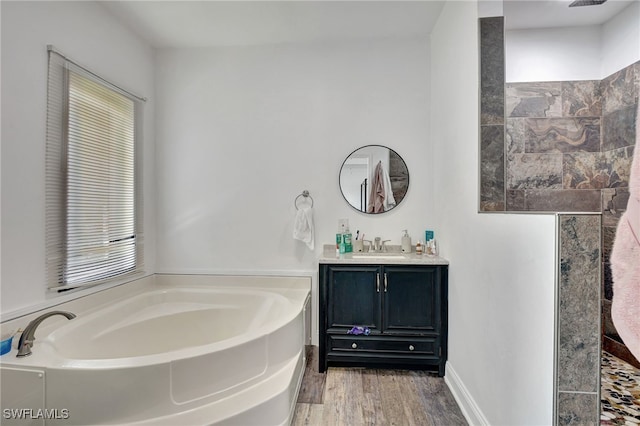 bathroom featuring a tub to relax in, vanity, and wood-type flooring