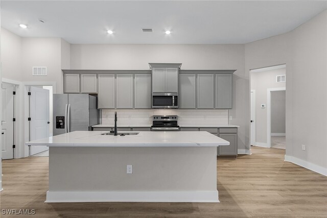 710 SW 21st St, Cape Coral, FL 33991 - kitchen with appliances with stainless steel finishes, gray cabinetry, a sink, a kitchen island with sink, and recessed lighting