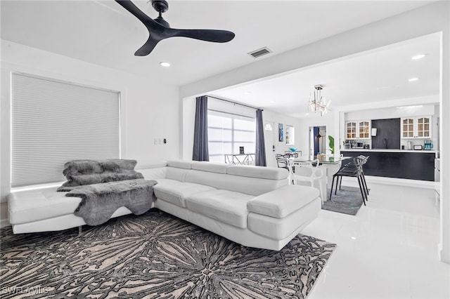 living room with ceiling fan with notable chandelier and tile patterned flooring