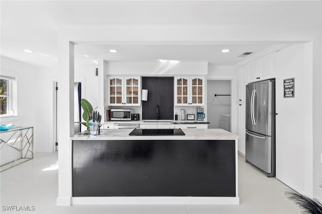 kitchen with tasteful backsplash, stainless steel appliances, light stone countertops, light tile patterned flooring, and white cabinetry