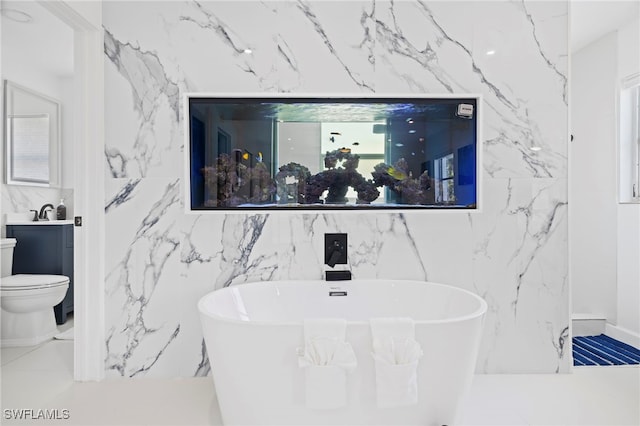 bathroom featuring tile walls, a bathtub, toilet, and tile patterned flooring