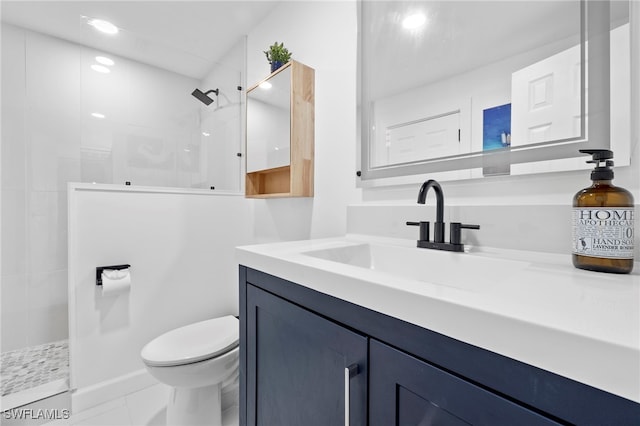 bathroom with tile patterned floors, toilet, vanity, and a tile shower