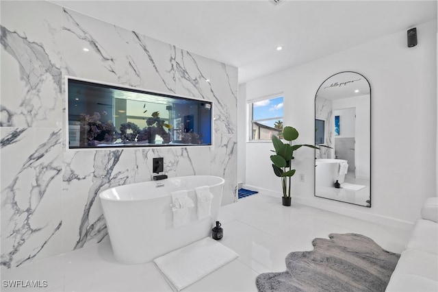 bathroom with tile patterned flooring, tile walls, and a bathtub