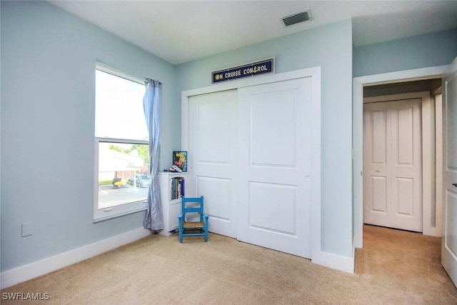 bedroom featuring light colored carpet and a closet