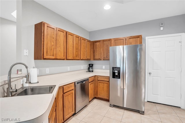 kitchen with stainless steel appliances, sink, and light tile patterned floors