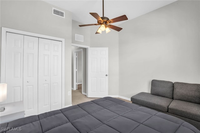 unfurnished bedroom with high vaulted ceiling, ceiling fan, carpet, and a closet